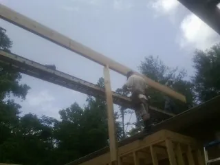 Carpenter setting a ridge beam over a new addition frame — Ice Dam Removal by Roofing Brothers in Sunbury